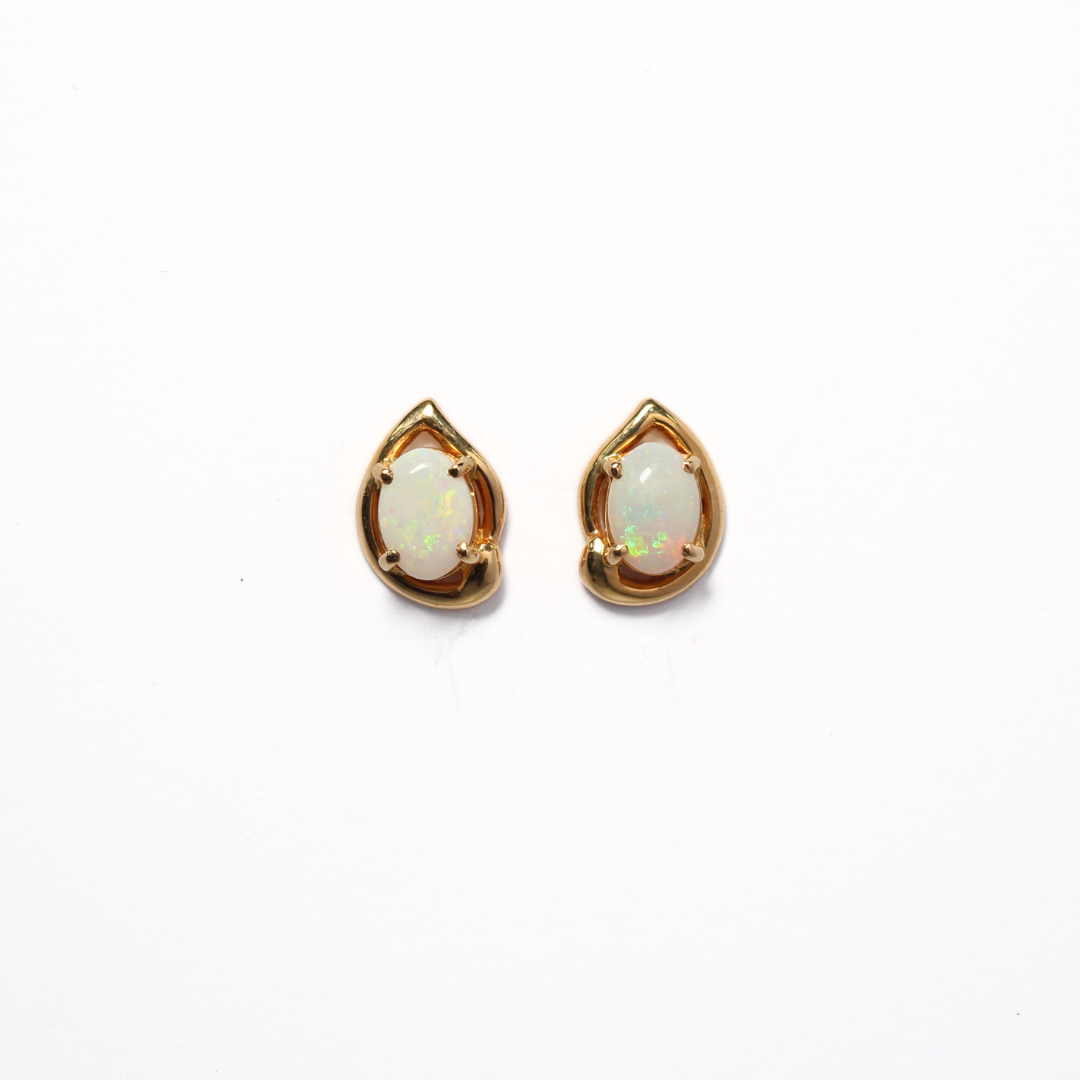 White milky opal earrings set in a a water drop shaped yellow gold setting.